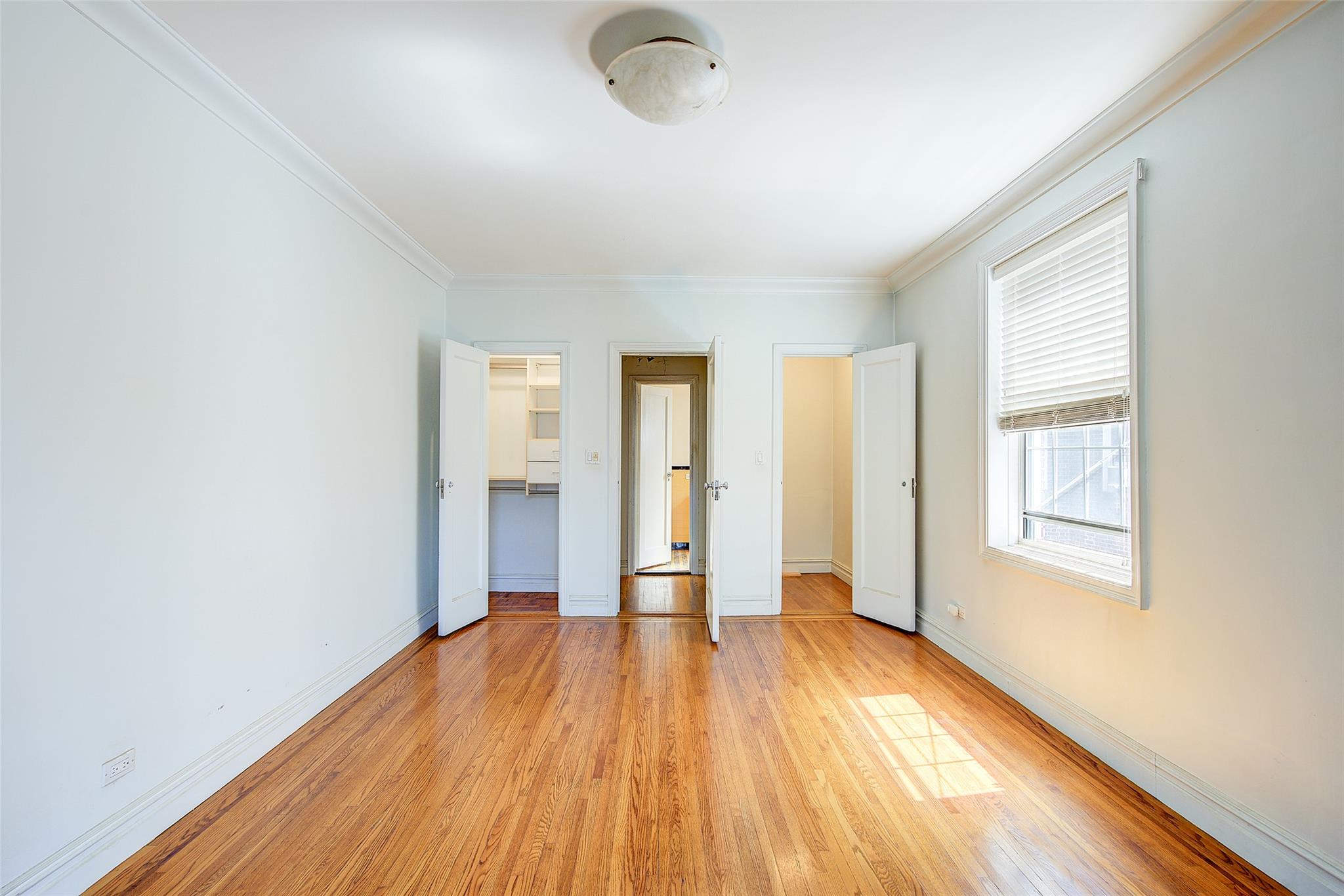 117-01 Park Lane South, Unit C5D Queens, NY 11418 - Photo 21 of 33 an empty room with wooden floor and windows