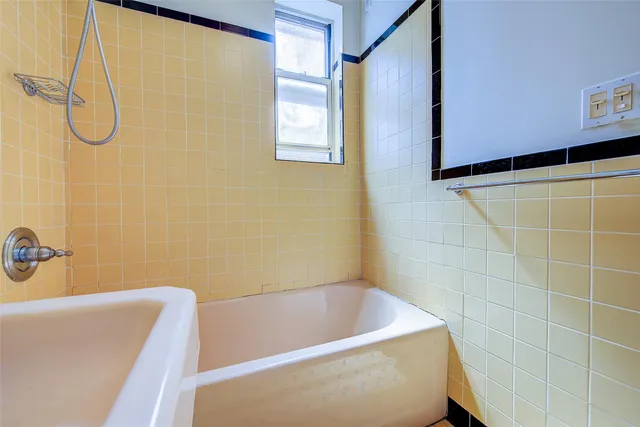 a bathroom with a white bath tub and a shower