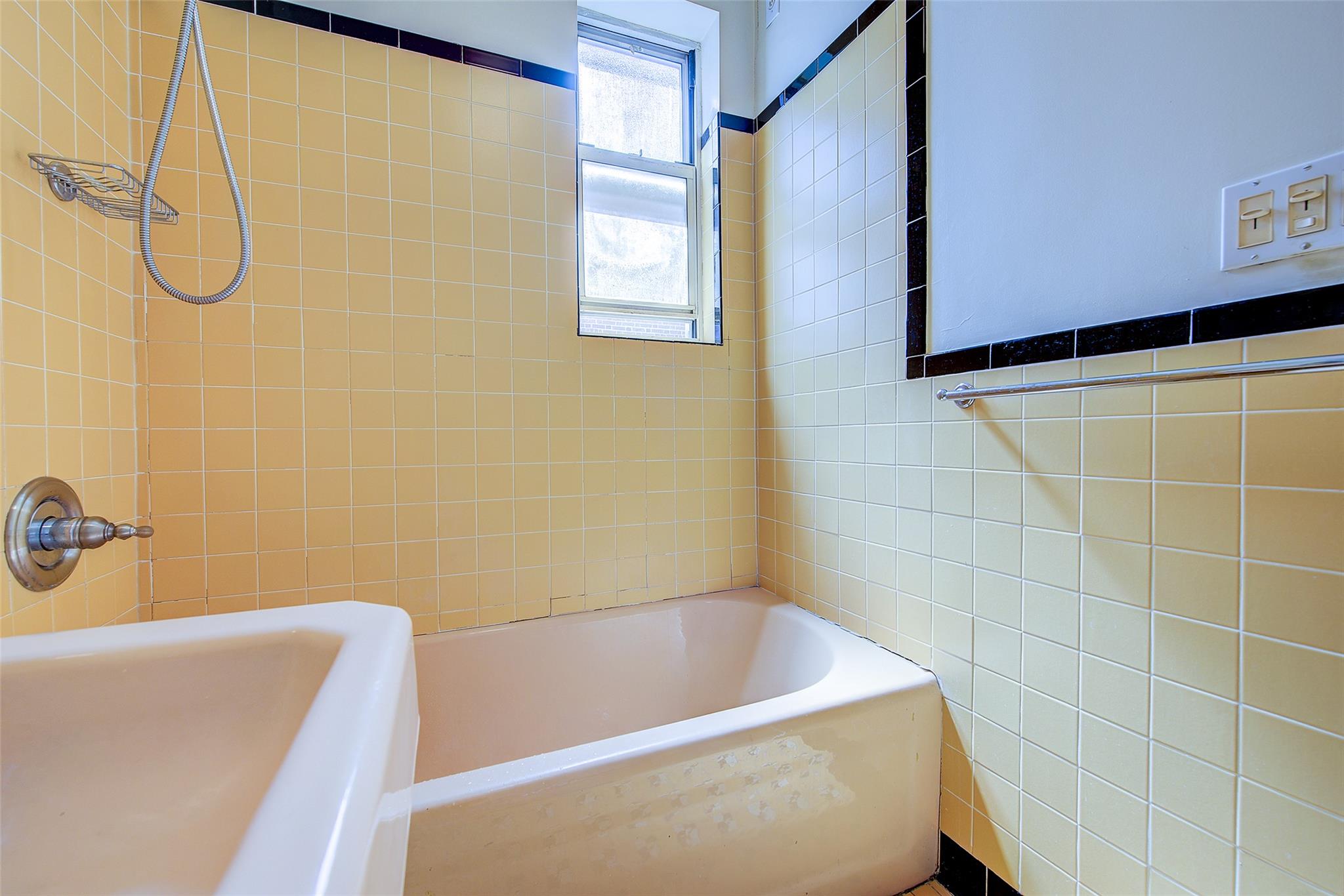 117-01 Park Lane South, Unit C5D Queens, NY 11418 - Photo 25 of 33 a bathroom with a white bath tub and a shower