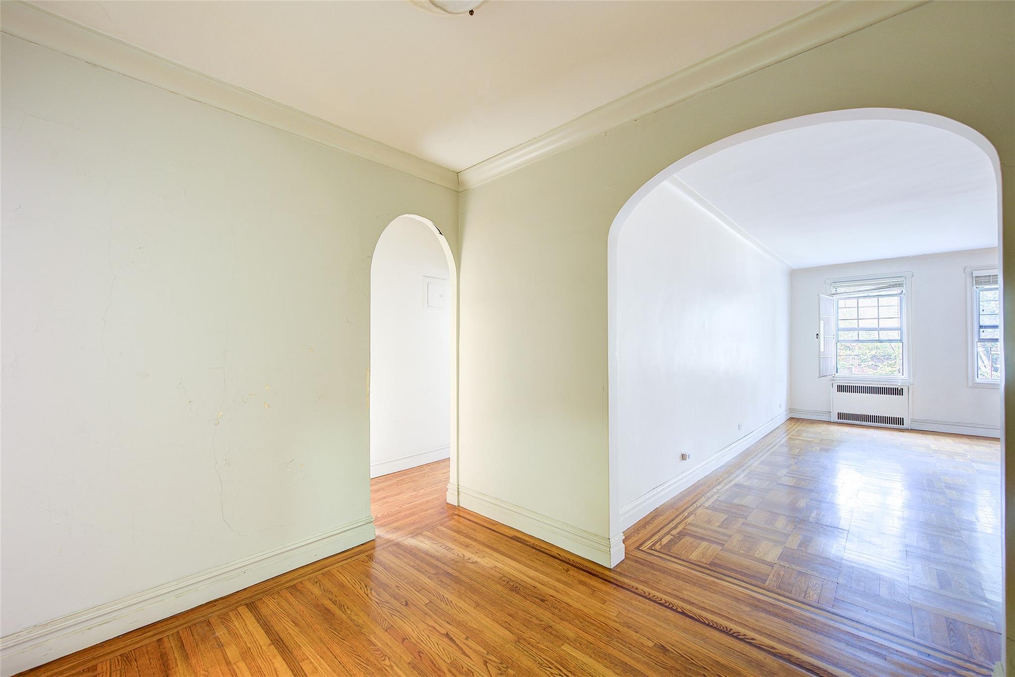 117-01 Park Lane South, Unit C5D Queens, NY 11418 - Photo 3 of 33 an empty room with wooden floor and windows
