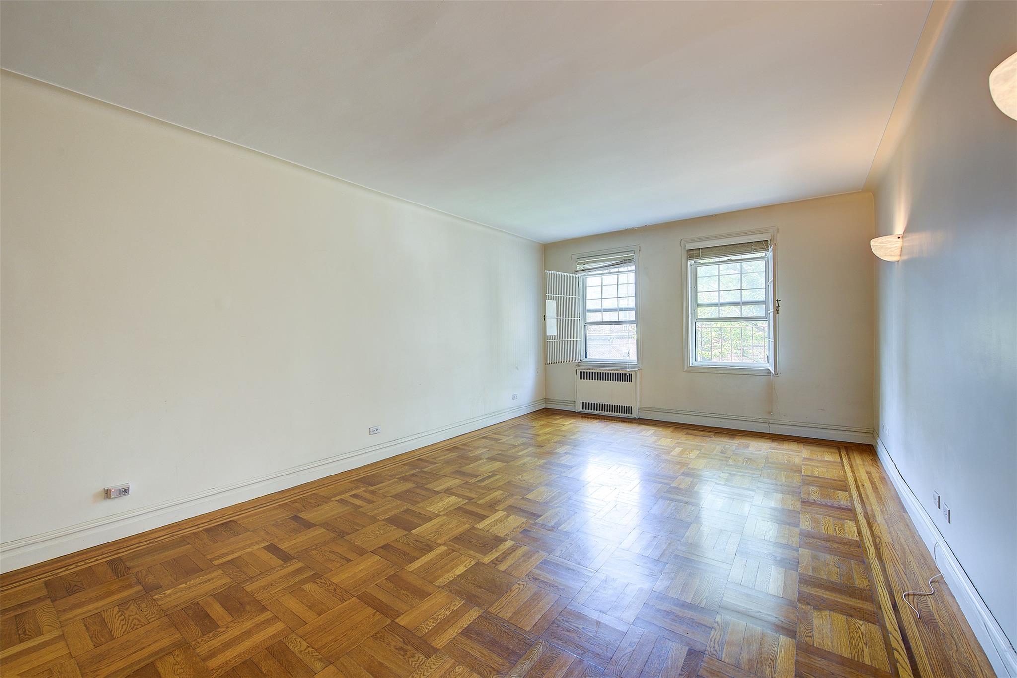 117-01 Park Lane South, Unit C5D Queens, NY 11418 - Photo 6 of 33 an empty room with wooden floor and windows