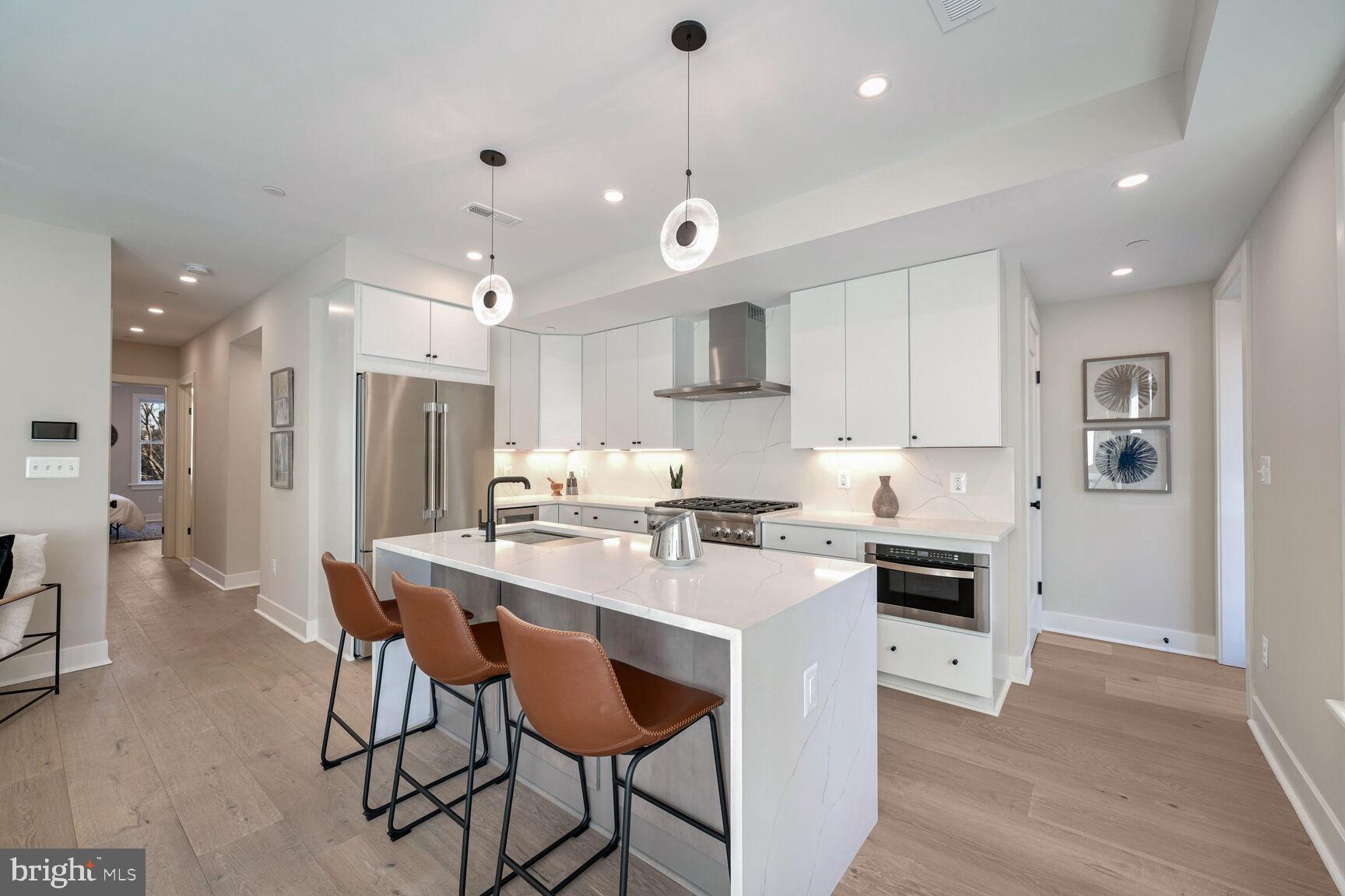 1820 19th Street Northwest, Unit 3 Washington, DC 20009 - Photo 4 of 27 a kitchen with stainless steel appliances a stove a refrigerator a sink a dining table and chairs