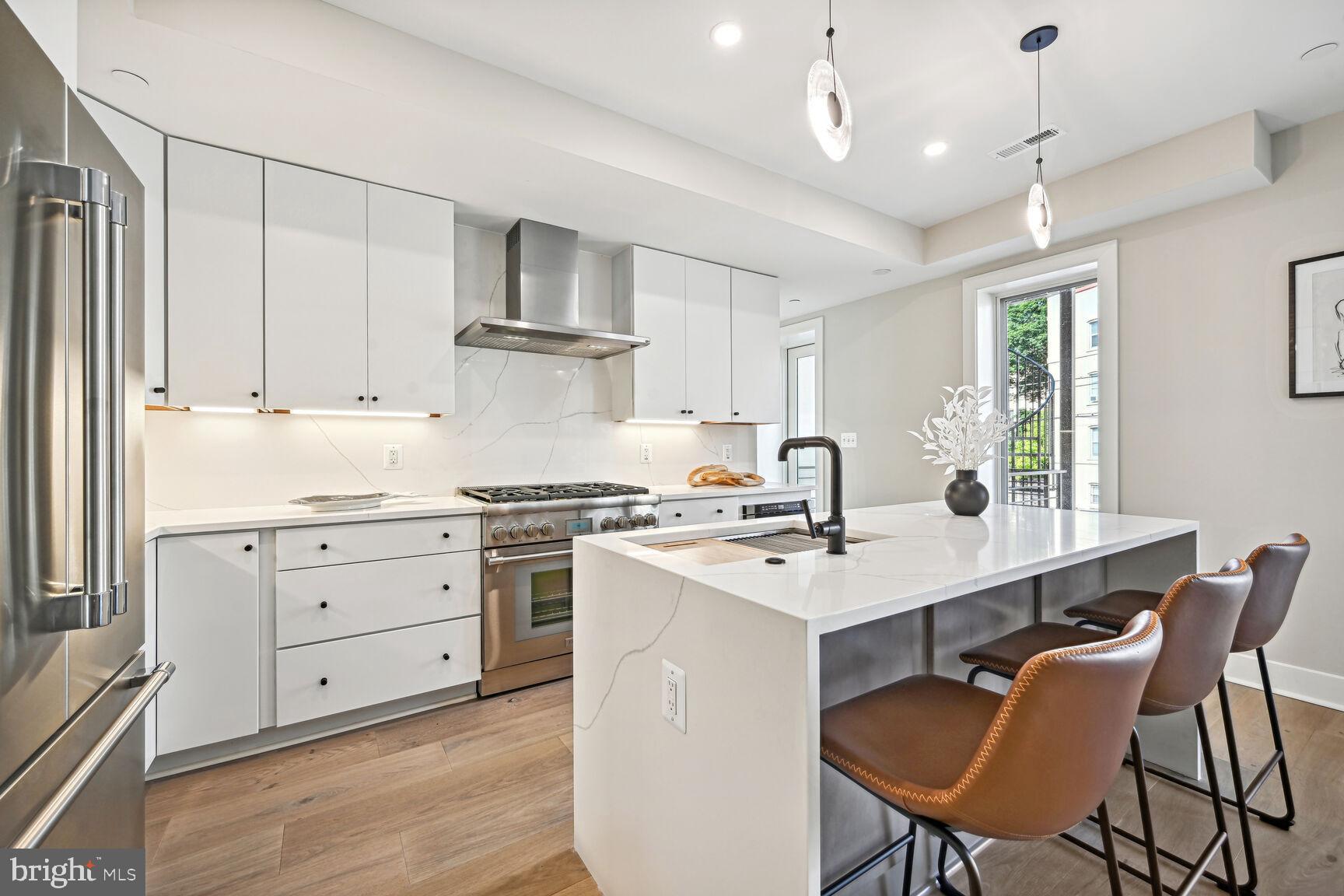 1820 19th Street Northwest, Unit 3 Washington, DC 20009 - Photo 5 of 27 a kitchen with a stove a sink a dining table and chairs