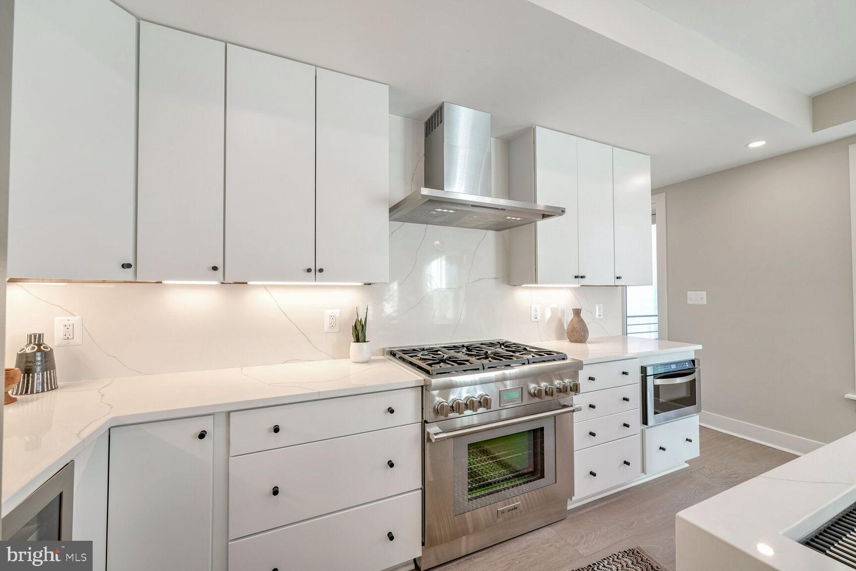 1820 19th Street Northwest, Unit 3 Washington, DC 20009 - Photo 6 of 27 a kitchen with white cabinets and a stove with a sink
