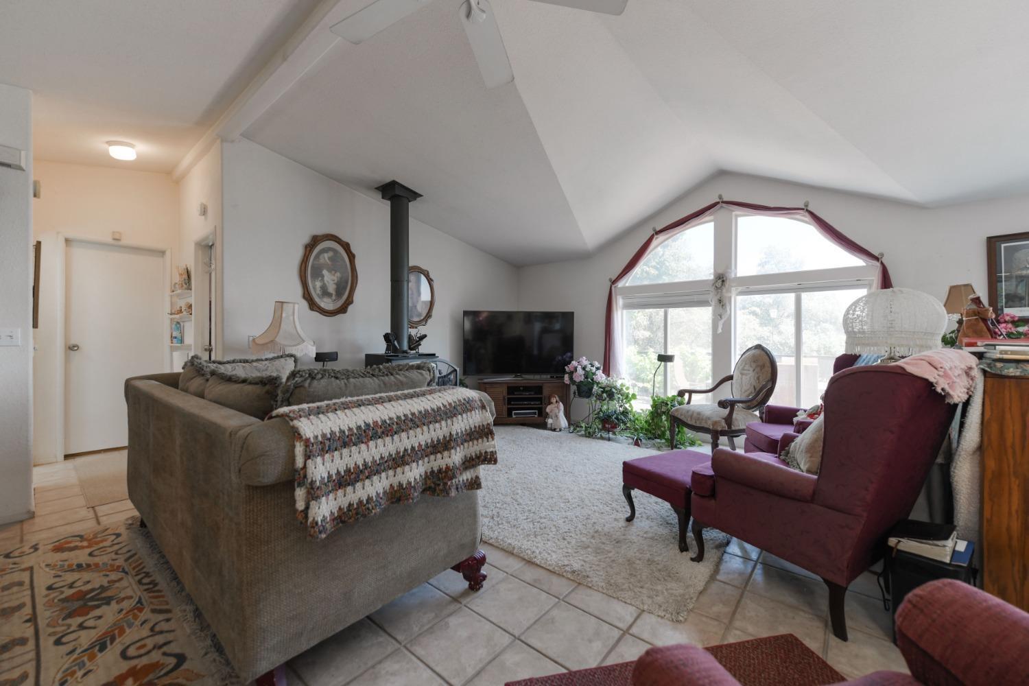 18301 Toyon Road Pine Grove, CA 95665 - Photo 6 of 15 a living room with furniture a fireplace and a large window
