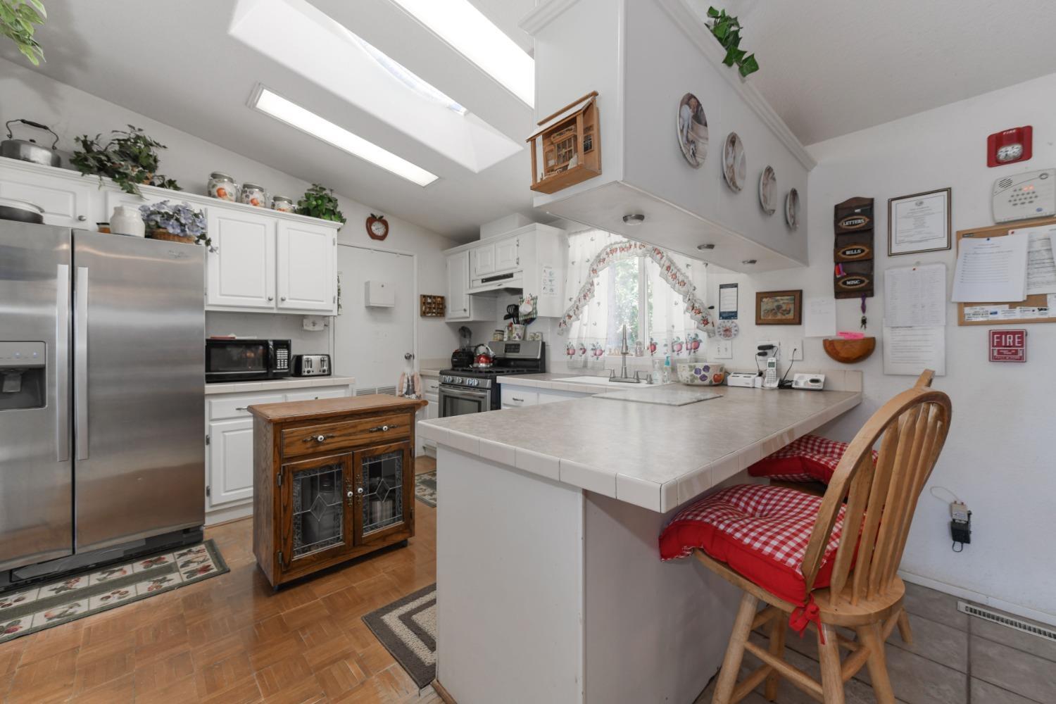 18301 Toyon Road Pine Grove, CA 95665 - Photo 7 of 15 a kitchen with stainless steel appliances granite countertop a sink a stove a refrigerator cabinets and chairs