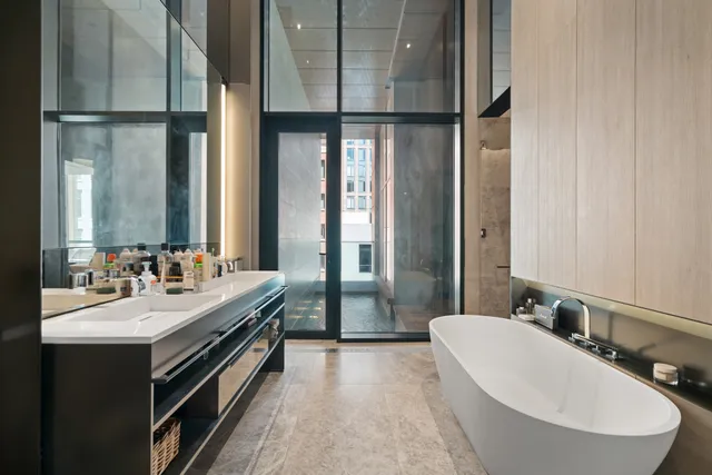 a bathroom with a double vanity sink a mirror and a bathtub