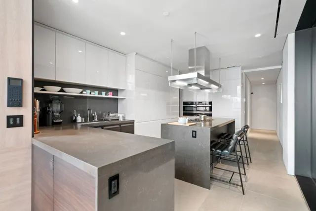 a kitchen with stainless steel appliances a kitchen island a stove a table and chairs in it