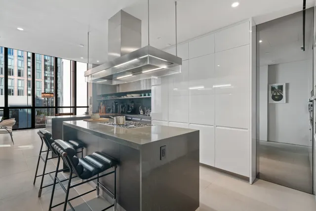 a kitchen with stainless steel appliances kitchen island granite countertop a sink and a refrigerator