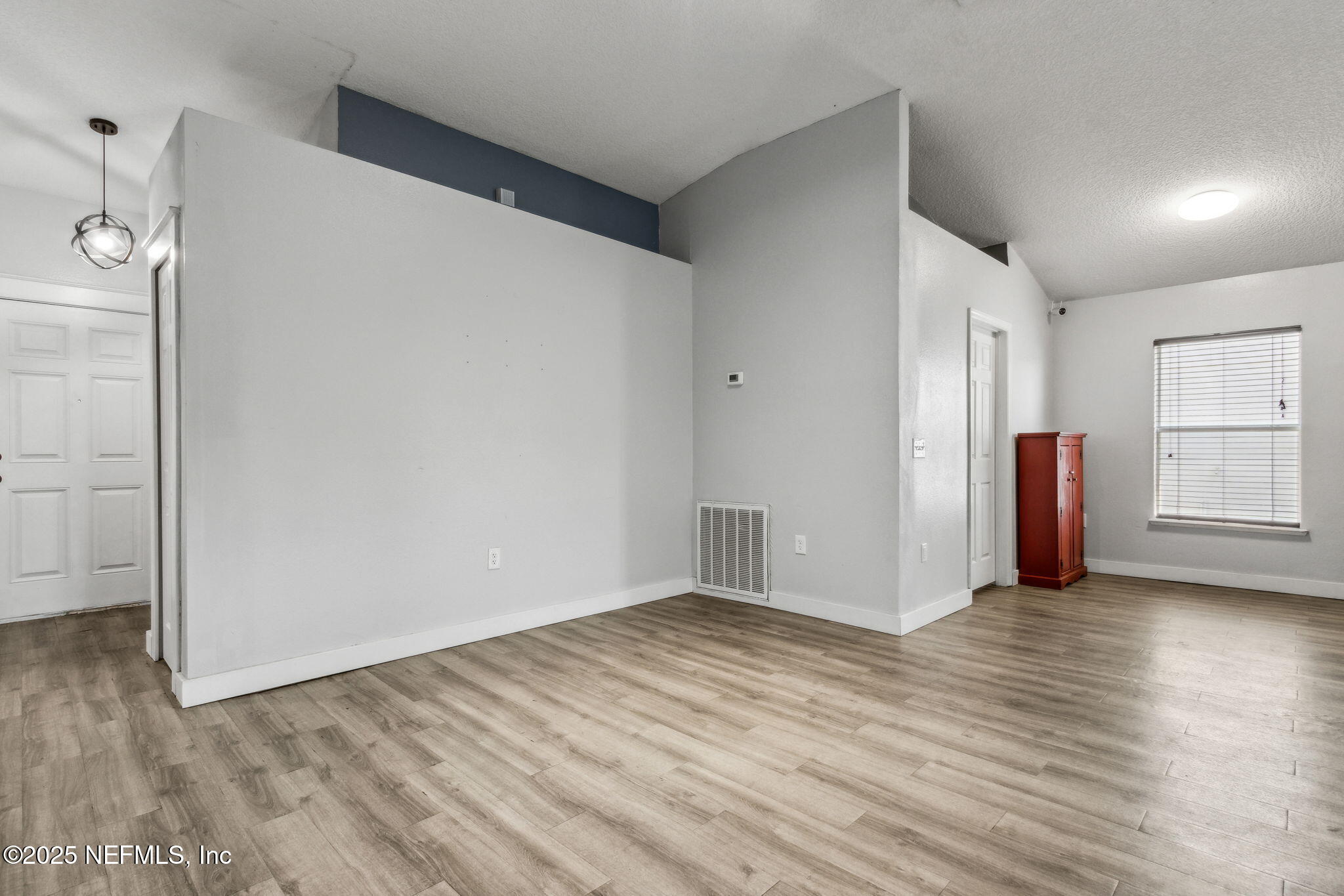 76564 Longleaf Loop Yulee, FL 32097 - Photo 12 of 54 a view of an empty room with wooden floor and a window