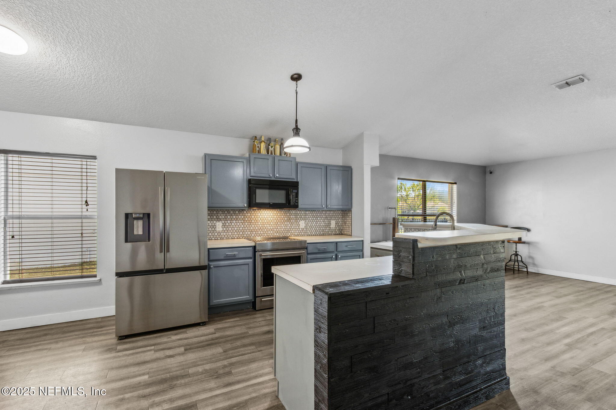 76564 Longleaf Loop Yulee, FL 32097 - Photo 16 of 54 a kitchen with kitchen island granite countertop a sink cabinets and stainless steel appliances