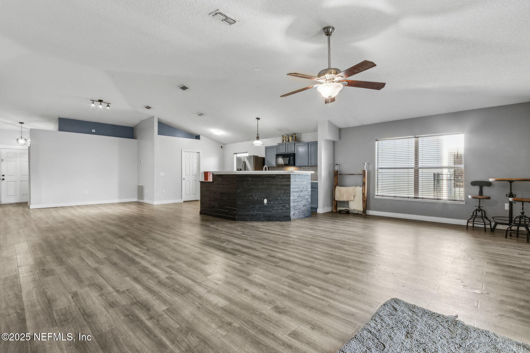 76564 Longleaf Loop Yulee, FL 32097 - Photo 25 of 54 a view of a kitchen with a stove cabinets a ceiling fan and wooden floor