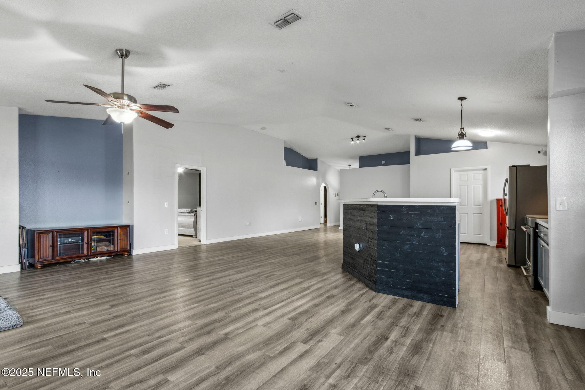 76564 Longleaf Loop Yulee, FL 32097 - Photo 27 of 54 a view of a livingroom with a fireplace a chandelier and wooden floor