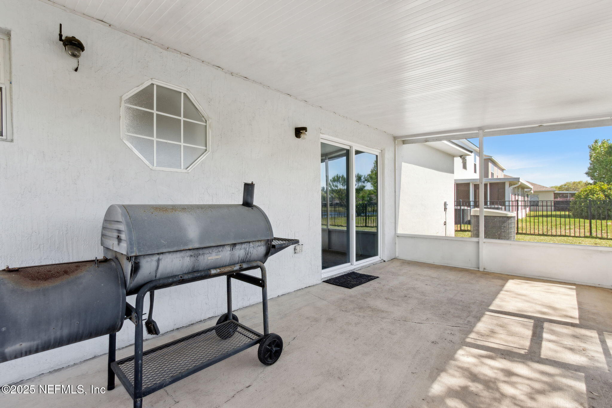 76564 Longleaf Loop Yulee, FL 32097 - Photo 45 of 54 a living room with furniture a flat screen tv and floor to ceiling window