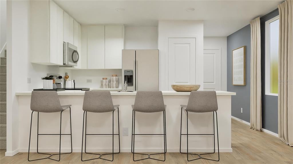 5620 Morant Bay Path Kissimmee, FL 34758 - Photo 2 of 34 a kitchen with stainless steel appliances kitchen island granite countertop a table and chairs