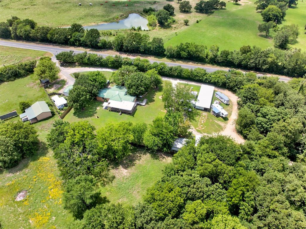 111 County Road 2806 Mabank, TX 75147 - Photo 29 of 34 Expansive property featuring multiple structures, a pond, and dense tree coverage