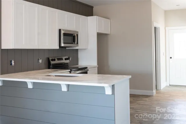 a kitchen with stainless steel appliances a stove microwave and sink