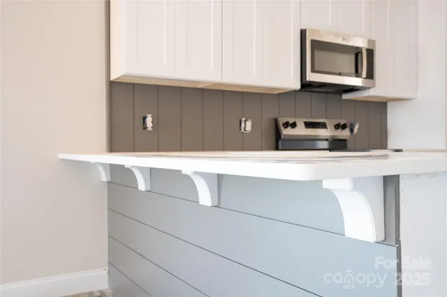 a kitchen with stainless steel appliances a white cabinet and a sink