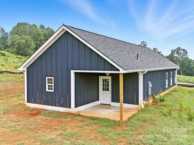 a view of house with backyard and parking space