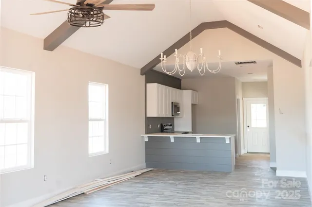 a view of a room with a chandelier and wooden floor