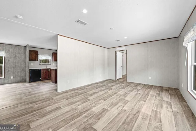 a view of empty room with wooden floor and fireplace