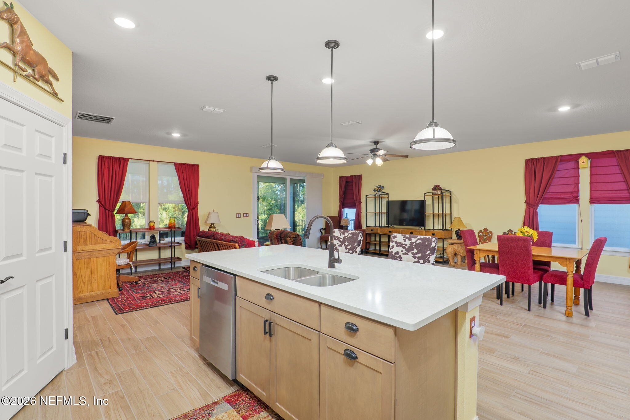 408 Del Webb Parkway Yulee, FL 32097 - Photo 17 of 29 a view of a kitchen with kitchen island a large counter top space appliances and a living room view