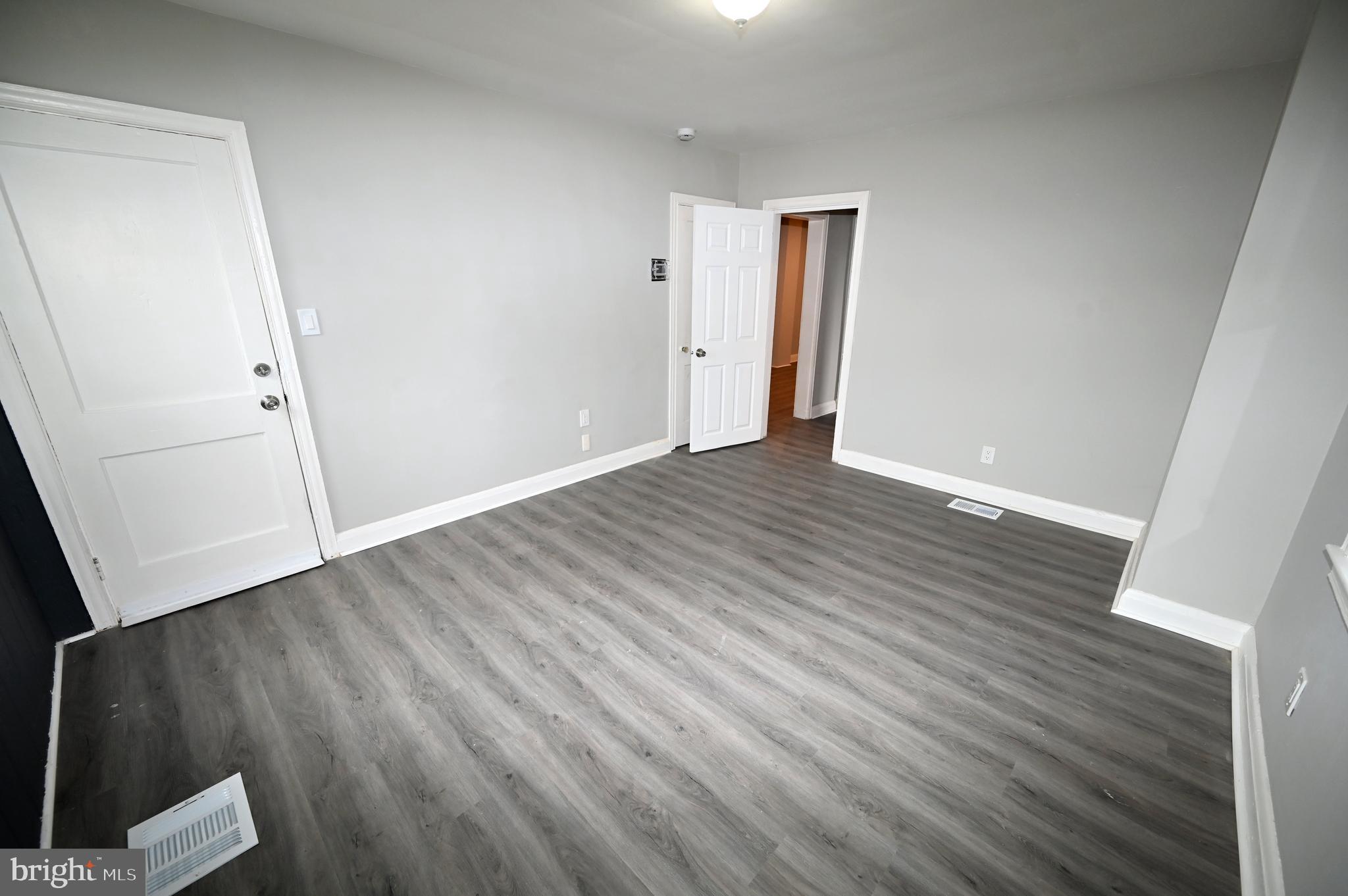 2952 Sollers Point Road, Unit B Dundalk, MD 21222 - Photo 11 of 37 an empty room with wooden floor and windows