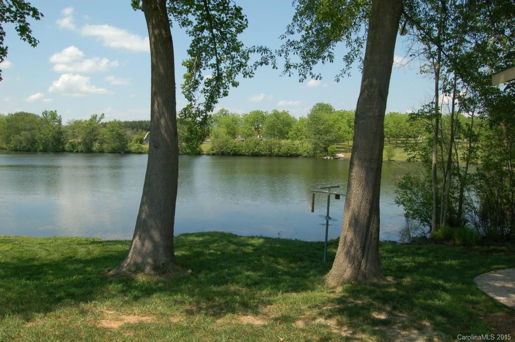 1880 Flat Rock Road York, SC 29745 - Photo 17 of 23 a view of a lake with a yard and large trees