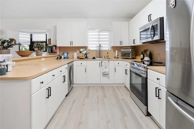 a kitchen with cabinets oven and a sink