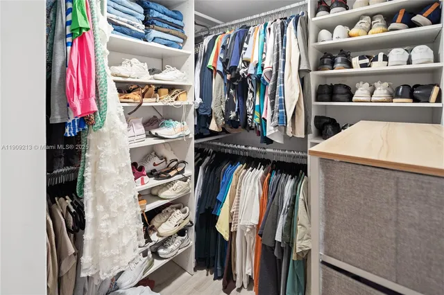 a view of walk in closet with clothes and shoes