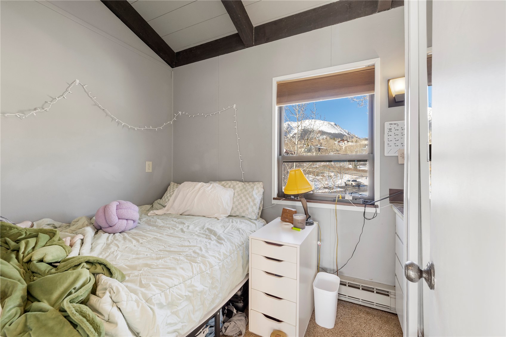 809 Ryan Gulch Road, Unit 809 Silverthorne, CO 80498 - Photo 16 of 17 Bedroom featuring carpet floors, baseboard heating, and vaulted ceiling with beams