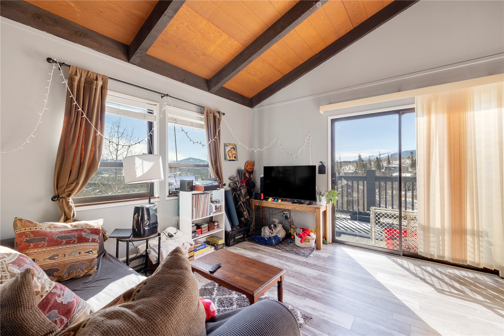 809 Ryan Gulch Road, Unit 809 Silverthorne, CO 80498 - Photo 8 of 17 Living room featuring wooden ceiling, wood finished floors, plenty of natural light, and lofted ceiling with beams
