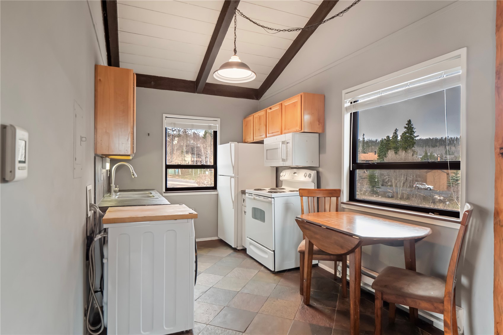 809 Ryan Gulch Road, Unit 809 Silverthorne, CO 80498 - Photo 10 of 18 a kitchen with a table chairs stove and refrigerator