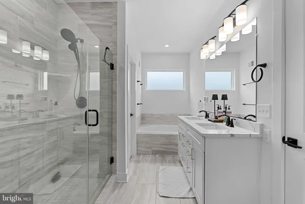 a bathroom with a double vanity sink mirror and shower