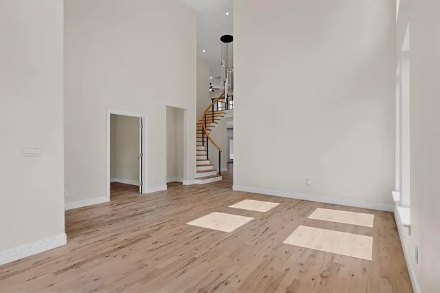 an empty room with wooden floor and white walls