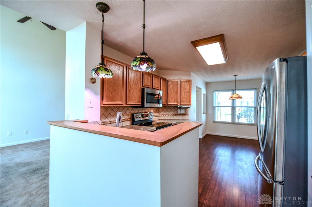 3915 East Summit Ridge Drive Beavercreek, OH 45430 - Photo 12 of 47 This bright kitchen features warm wooden cabinetry and modern appliances, creating a welcoming atmosphere.