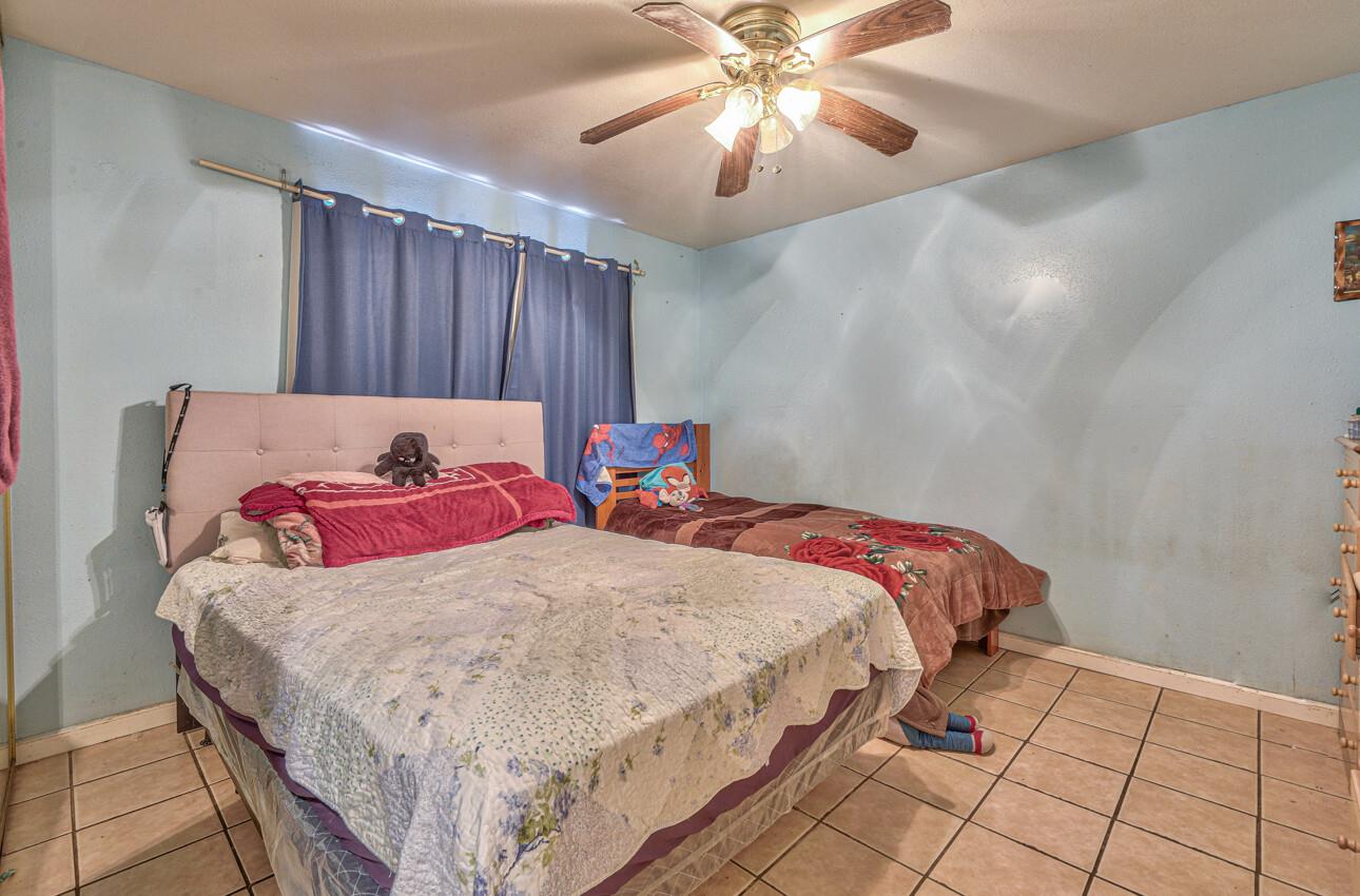 415 Michael Circle Gonzales, CA 93926 - Photo 9 of 16 a bedroom with a bed and a chandelier