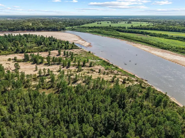 a view of a pathway both side of grassy field with shrub