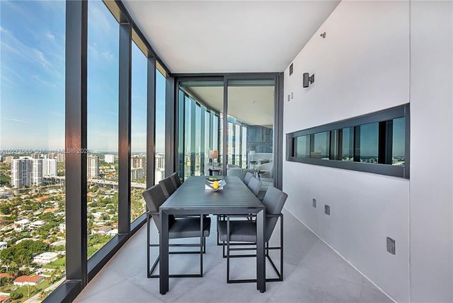 a table and chairs in a room next to a window