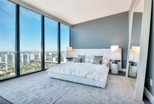 a bedroom with a large bed and a large window