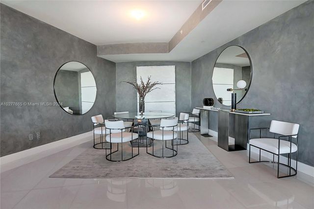 a living room with furniture a mirror and a large mirror next to a window