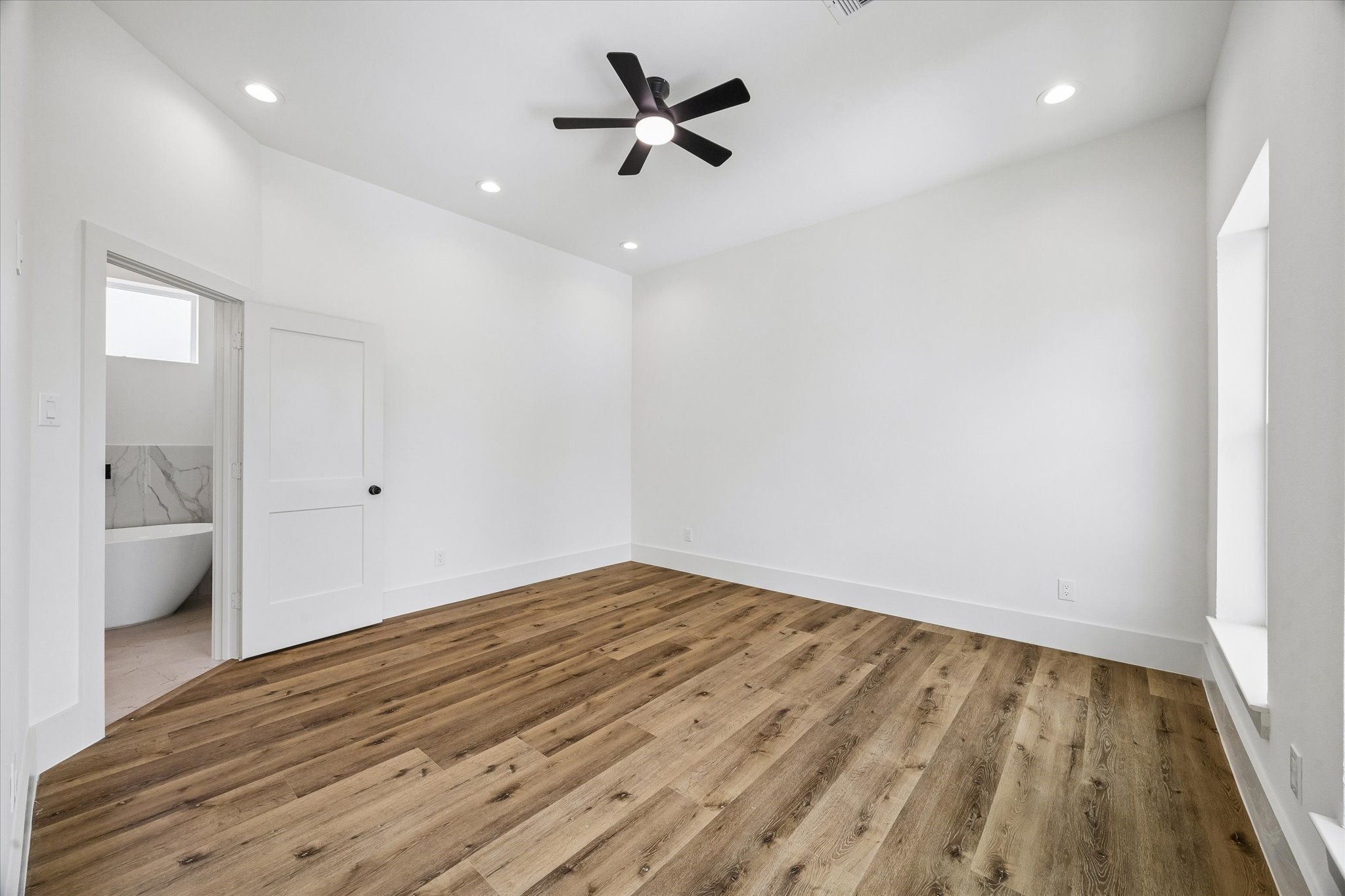 5508 Hardy Street Houston, TX 77009 - Photo 4 of 31 an empty room with wooden floor and a ceiling fan