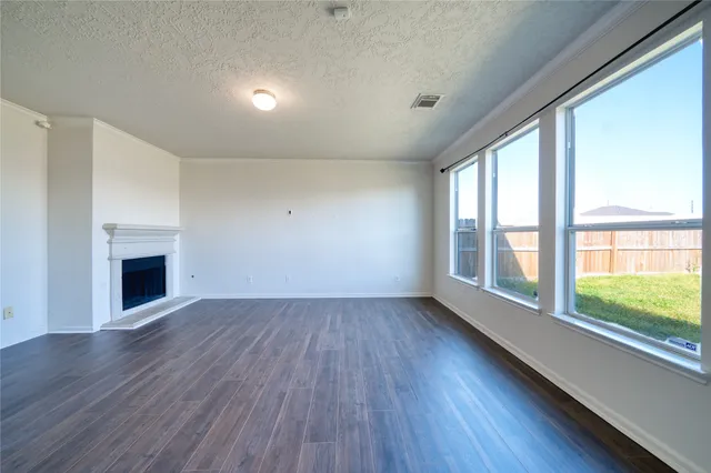a view of empty room with wooden floor and fireplace