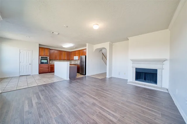 a view of a electric appliances in kitchen and empty room with wooden floor