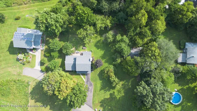 an aerial view of a house with garden space and street view