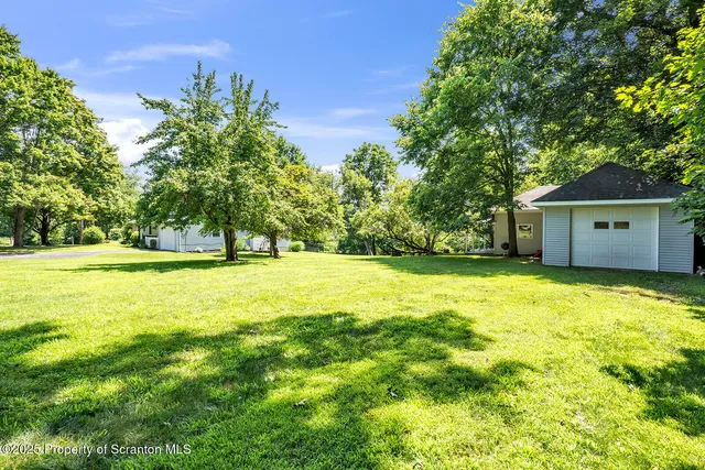 a view of a hallway with wooden floor and windows