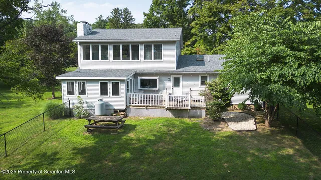 an aerial view of a house with a yard and lake view