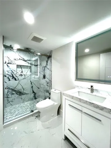 a bathroom with a granite countertop shower a toilet and a sink