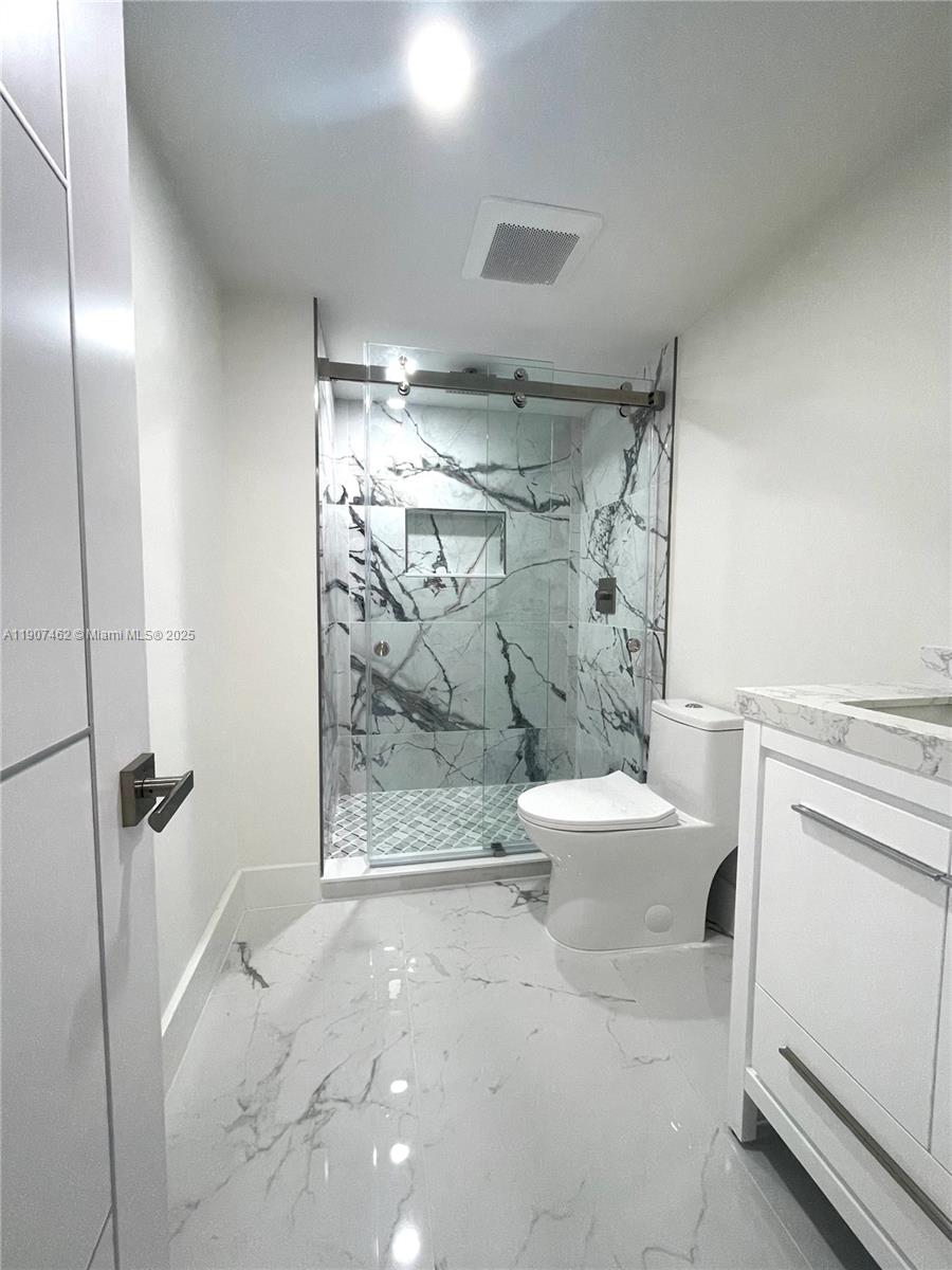3430 Galt Ocean Drive, Unit 908 Fort Lauderdale, FL 33308 - Photo 14 of 17 a bathroom with a granite countertop shower a toilet and a sink