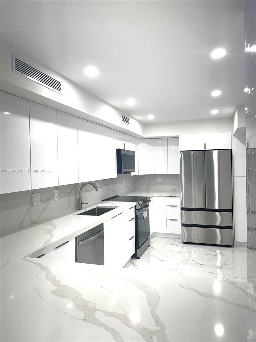 3430 Galt Ocean Drive, Unit 908 Fort Lauderdale, FL 33308 - Photo 5 of 17 a kitchen with stainless steel appliances kitchen island granite countertop a refrigerator and a stove top oven